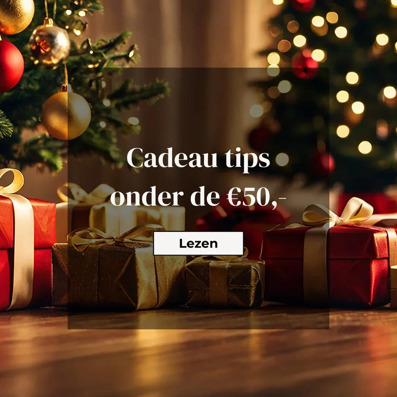 Kerstcadeaus onder kerstboom met gouden en rode ballen, cadeau tips onder de €50