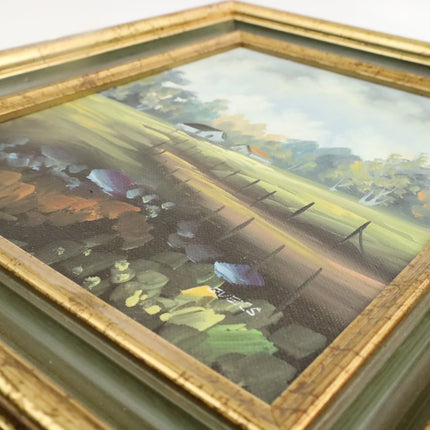 Landschapsschilderij met boerderij en hekken, bloemen en bomen, in goudkleurige houten lijst