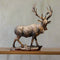 Bronzen beeld van een hert met grote geweien staand op houten plank tegen neutrale achtergrond