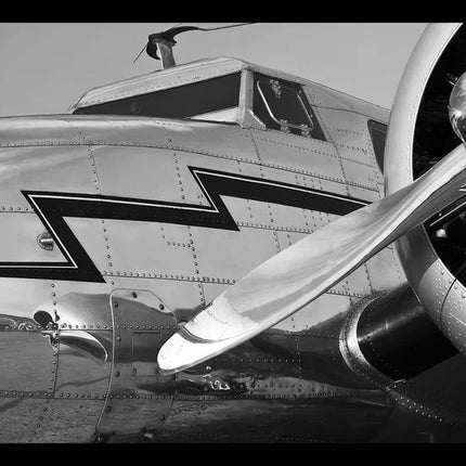 Zwart-wit close-up van piekfijn gepolijst retro vliegtuig met metalen propeller en zigzagdecoratie