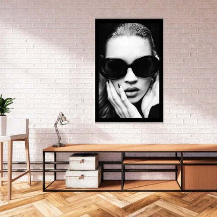 Moderne woonkamer met houten meubels, zwarte lamp, groene plant en zwart-wit portret van vrouw met zonnebril aan muur