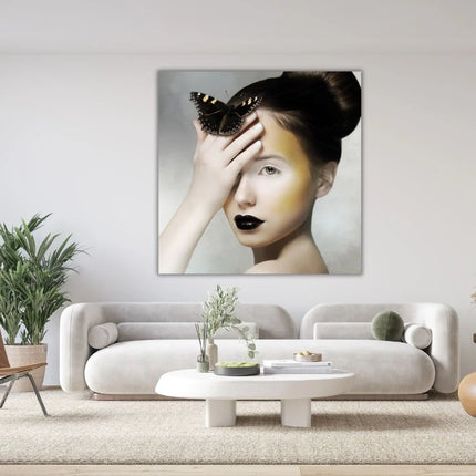 Moderne woonkamer met groot kunstwerk van vrouw met zwarte vlinder en opvallende make-up