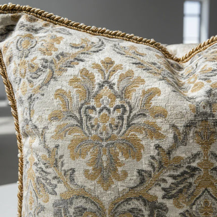 Sierkussen met goudgrijs barok patroon en gouden koordrand in modern interieur
