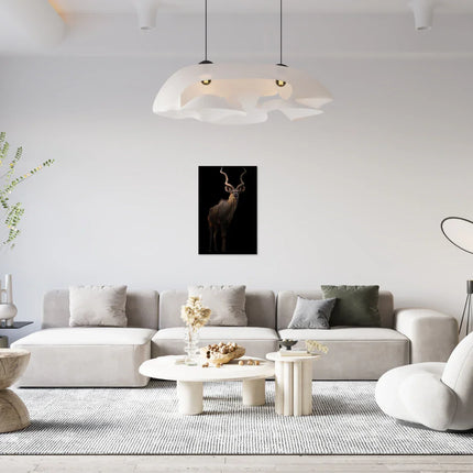 Modern woonkamer met beige bank, ronde tafels, en een dierenposter van een kudu